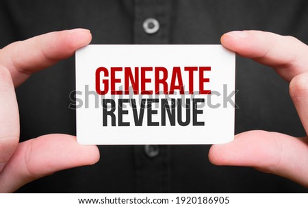 Businessman holding a card with text GENERATE REVENUE,business concept