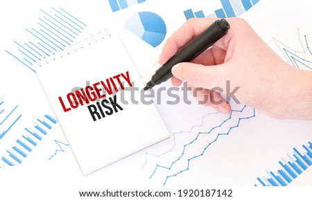 Businessman holding a black marker, notepad with text LONGEVITY RISK,business concept
