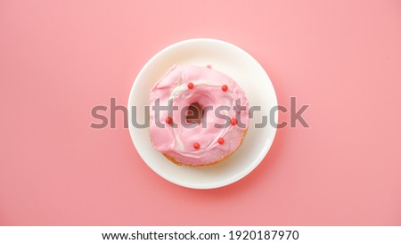pink donut with topping on a pink background. Sweets, high sugar