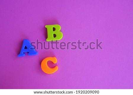 ABC 3D plastic colorful letters on purple background with copy sapce on the right side
