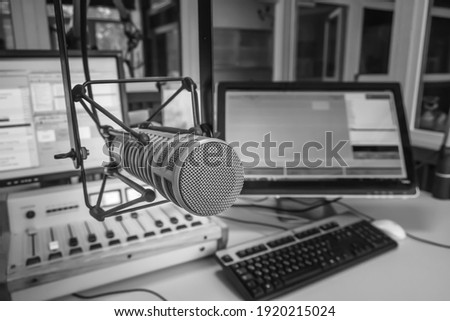 Radio station studio. Professional microphone, audio console and computer screens