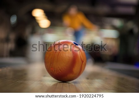 Woman playing bowling game. Focus is on bowler. 
