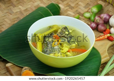 Focus on the center of the bowl Nila Masak Bogo or Turmeric clear Tilapia soup, especially for freshwater fish from Indonesia. Healthy food with local herbs and spices  Royalty-Free Stock Photo #1920265457