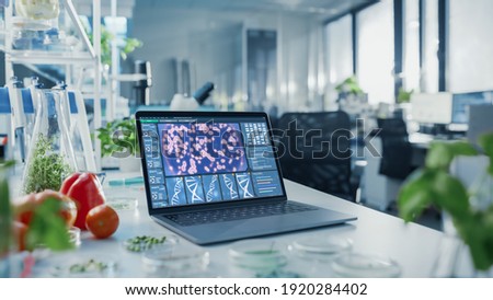 Shot of a Laptop Computer with Display Showing Gene Editing Interface in Modern Labolatory. Bright Modern Food Laboratory with Advanced Technological Equipment.