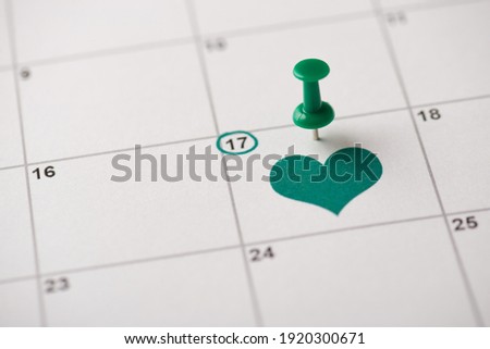 St. patrick's day is coming concept. Cropped close up view photo picture of pushpin attached to the calendar with green heart