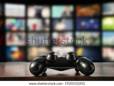 Gamepad on table with TV screen on background