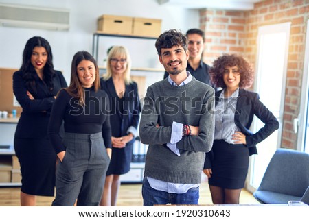 Group of business workers smiling happy and confident. Posing together with smile on face looking at the camera, young handsome man with crossed arms at the office