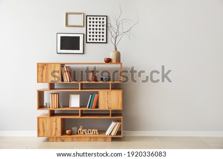 Shelving unit with books and decor in interior of room Royalty-Free Stock Photo #1920336083