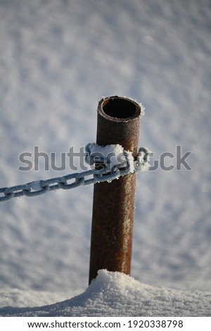 
winter, very cold, a metal column drowned in snow
