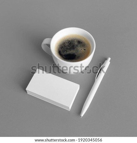 Blank stationery and ID template on gray paper background. Business cards, coffee cup and pen. Mock-up for branding identity for designers.