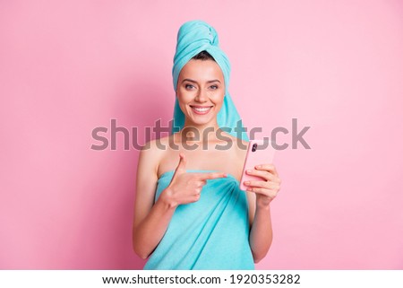 Photo of young attractive smiling cheerful positive charming girl point finger at smartphone isolated on pink color background