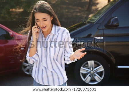 Stressed woman talking on phone after car accident outdoors Royalty-Free Stock Photo #1920373631