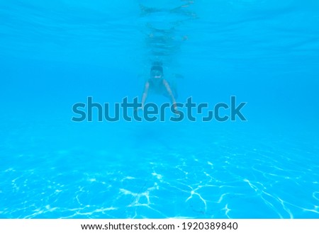 blurred boy swimming under blue water in pool, child water diving. Holiday, summer vacation, active healthy lifestyle, activity concept