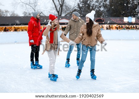 Group of friends skating at outdoor ice rink