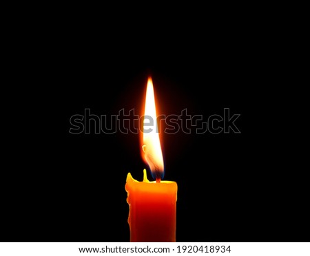 One light candle burning brightly,Candle light close up on black background. Burning candle. Candle Flame.               