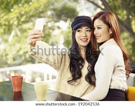 young friends taking selfie in coffee shop.