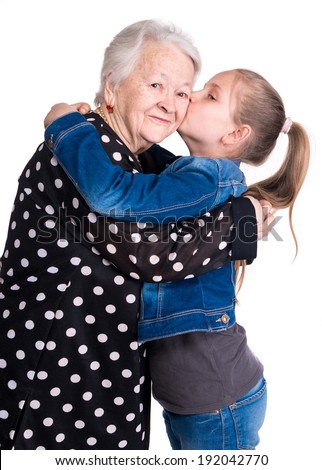 Granddaughter kissing her grandmother on white background