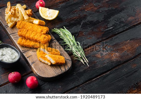 Fish Sticks with vegetables set, on wooden cutting board, on old dark wooden table background , with copyspace and space for text