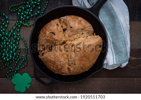 Photograph of Irish Soda Bread baked in a cast iron skillet for Saint Patrick's Day with Shamrock Beads Royalty-Free Stock Photo #1920511703