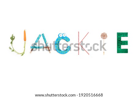 The girls name 'Jackie' made from household items, carrot, chopsticks, straws, allium on white background