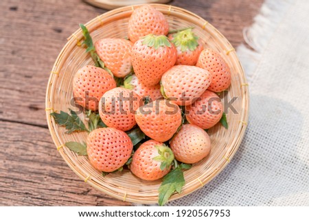 Fresh white strawberries with leaves on bamboo basket, White strawberry in Bamboo basket on wooden table. Royalty-Free Stock Photo #1920567953