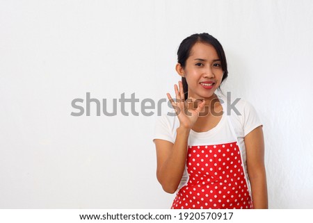 Portrait of asian woman wearing kitchen apron while showing her okay gesture. Isolated on white background