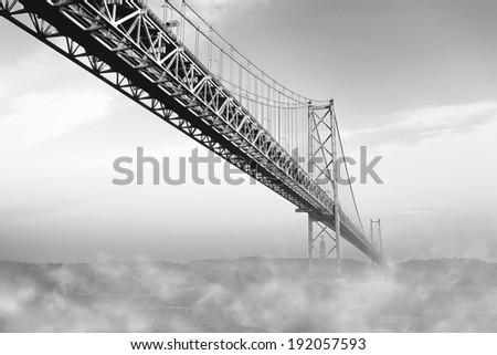 The bridge of April 25 with a fog on a river, Lisbon, Portugal. Monochromatic picture