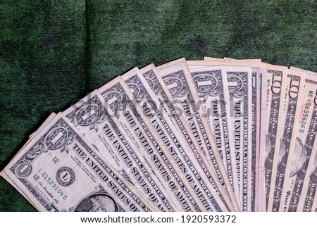 Dollar bills on textured wooden green background
