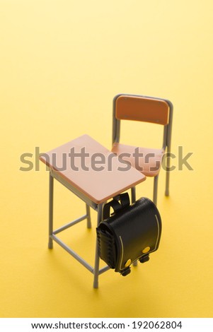school desk on yellow background