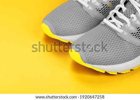 Gray sneakers on a yellow background sport concept, free space. Free space