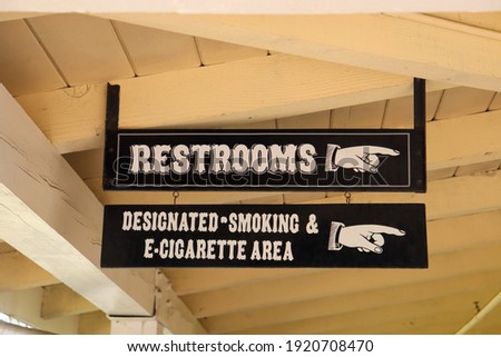 Restrooms and designated smoking and E-Cigarette area signs at the Old Poway Park in Poway, California.