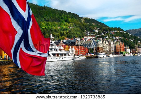 Norwegian flag with the port of Bergen and view on the historical buildings of Bryggen in Bergen, Norway Royalty-Free Stock Photo #1920733865