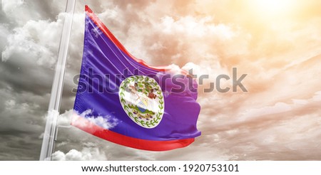 Belize national flag cloth fabric waving on beautiful grey sky.