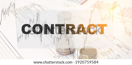 Financial word - Contract, on an office table with diagrams