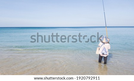The picture of the sea and the sky on a clear day With woman standing fishing far away at the beach