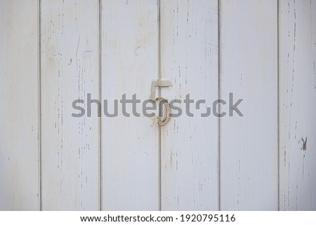 Number five on a wood white door