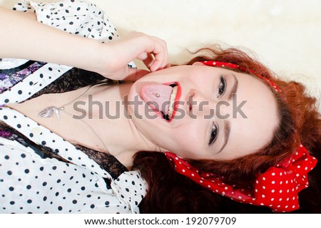 picture of closeup on funny beautiful blond young woman having fun showing tongue happy smiling & looking at camera on white background