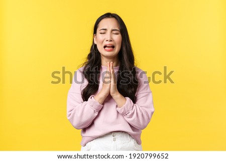 People emotions, lifestyle and fashion concept. Desperate and sad gloomy asian girl begging for forgiveness, crying heart out and praying, pleading god mercy, standing yellow background Royalty-Free Stock Photo #1920799652