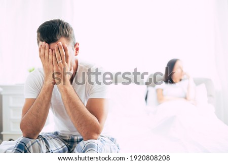 Young unhappy married couple in bedroom. Serious quarrel in family during covid-19 quarantine