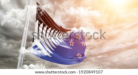 New Zealand national flag cloth fabric waving on beautiful grey sky.