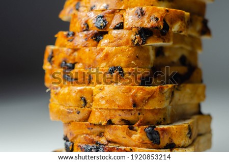 Fruit loaf with sultanas and orange flavored pieces on the white background, traditional fruit bread
