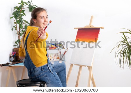 Female artist painting in workshop, white background