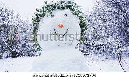 Cute snowman smiling with hat and carrot in winter season. Happy new year and outdoor activities concept in park.