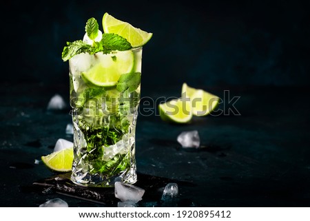 Mojito cocktail or mocktail with lime, mint, and ice in glass on blue background. Summer cold alcoholic non-alcoholic drink,  beverage and cocktail. Copy space Royalty-Free Stock Photo #1920895412
