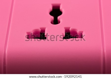 Closeup picture of a pink outlet isolated on black. Electric Power Line on balck background