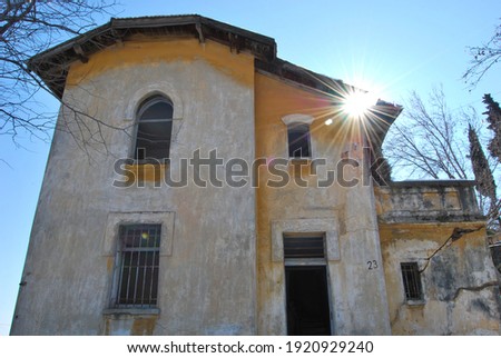 Sunburst over an abandoned yellow old house