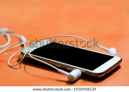 Minimal work space - Creative flat lay photo of workspace desk with earphones and mobile phone with blank screen on copy space white background. Top view mock up , flat lay photography.