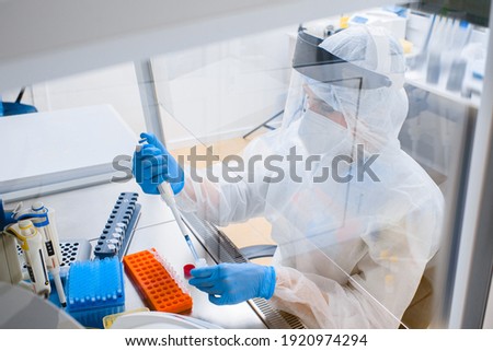 Laboratory assistant in a protective suit and mask in a modern prc laboratory Royalty-Free Stock Photo #1920974294