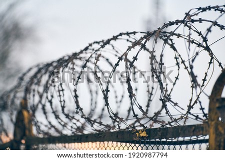 Barbed wire on fence of restricted area. No unauthorized entry. Old fence of military border territory