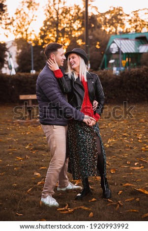 Man and woman. Autumn. Park. The man holds the woman's hand, hugging